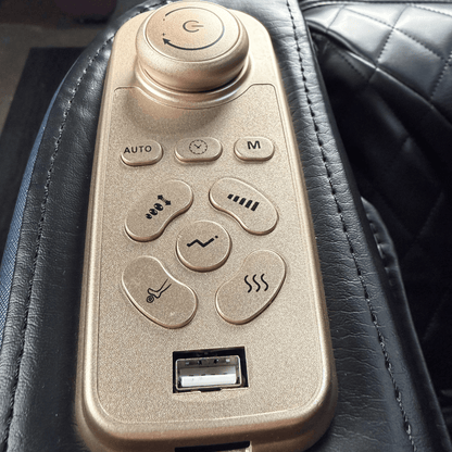 close-up van goudkleurig bedieningspaneel op armleuning van zwarte massagestoel met usb poort