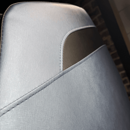 close-up van lichtblauw zijpaneel van massagestoel met donker detail