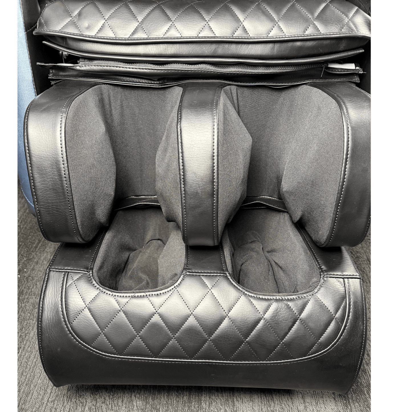 close-up van zwart voet en kuitgedeelte van massagestoel met quilted patroon
