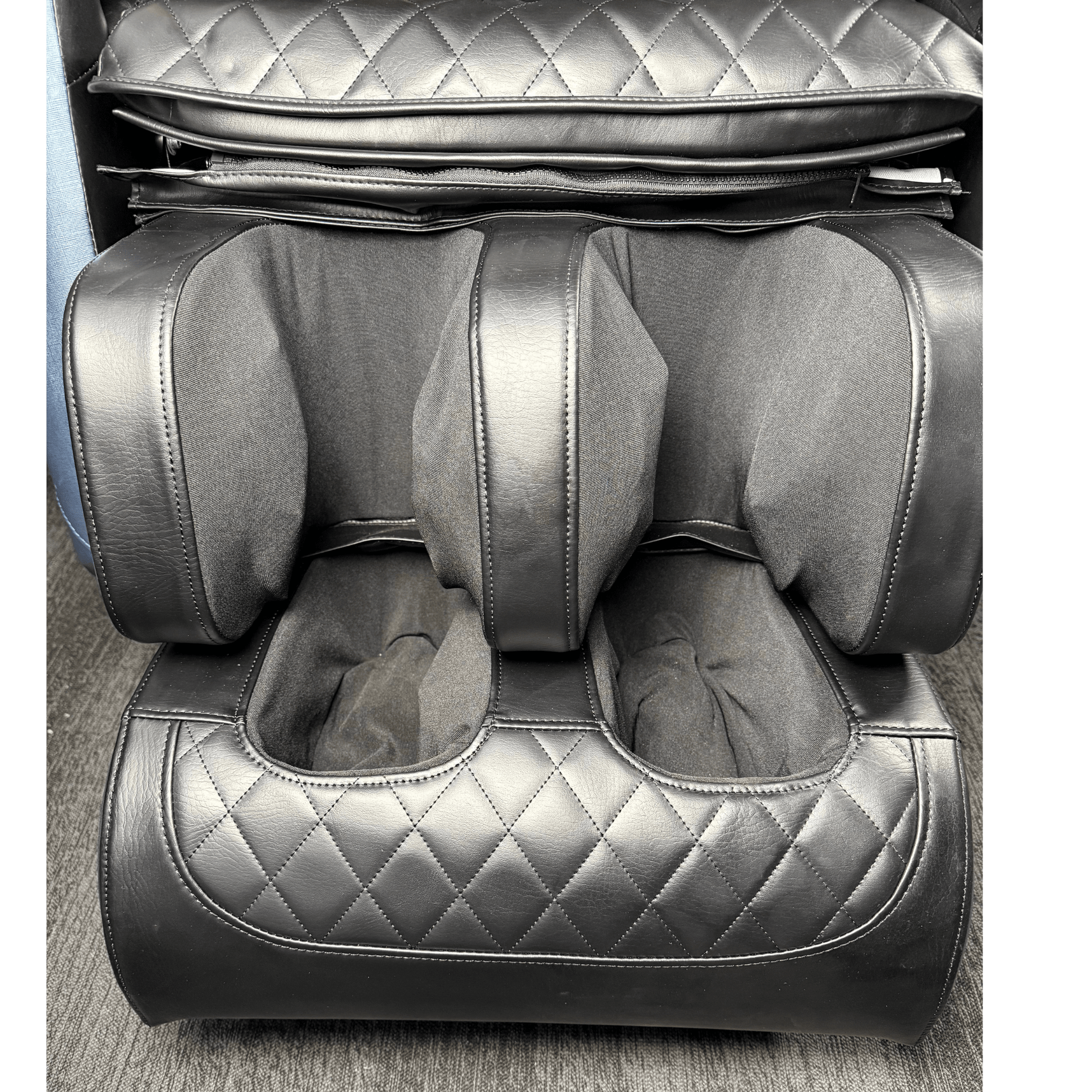 close-up van zwart voet en kuitgedeelte van massagestoel met quilted patroon