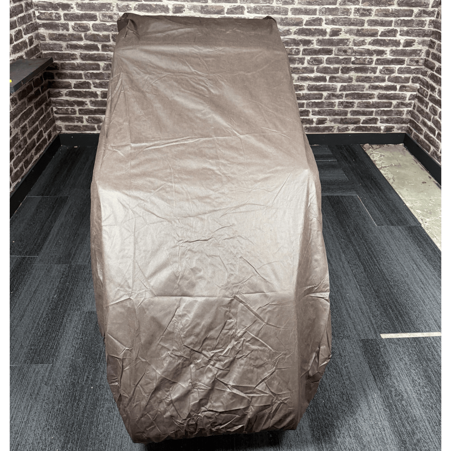 massagestoel met bruine beschermhoes in showroom setting